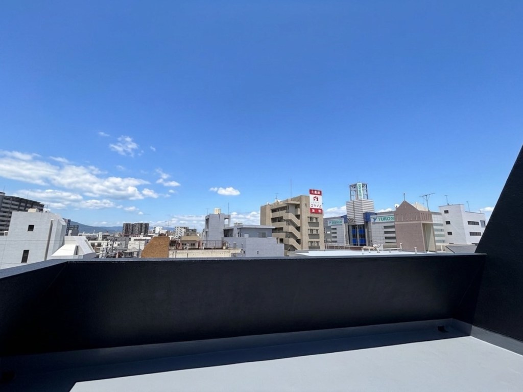 青空と建物が見える屋上の景色