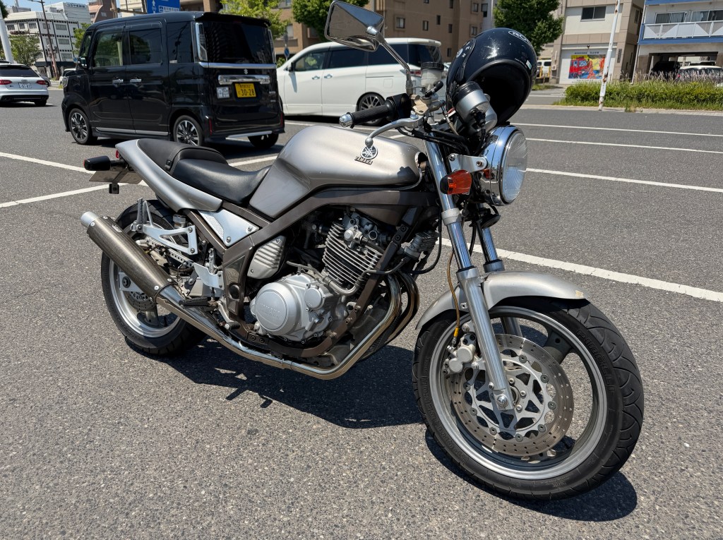 シルバーのバイクが道路の脇に停車している。